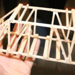 Someone is holding a balsawood bridge