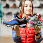 A girl is holding two sport shoes.