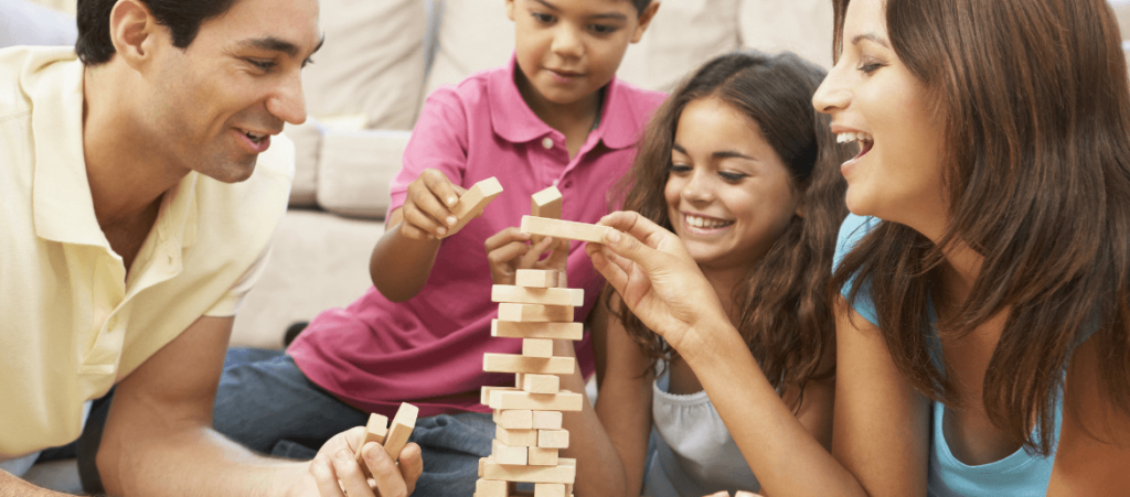 A family of four people play Jenga